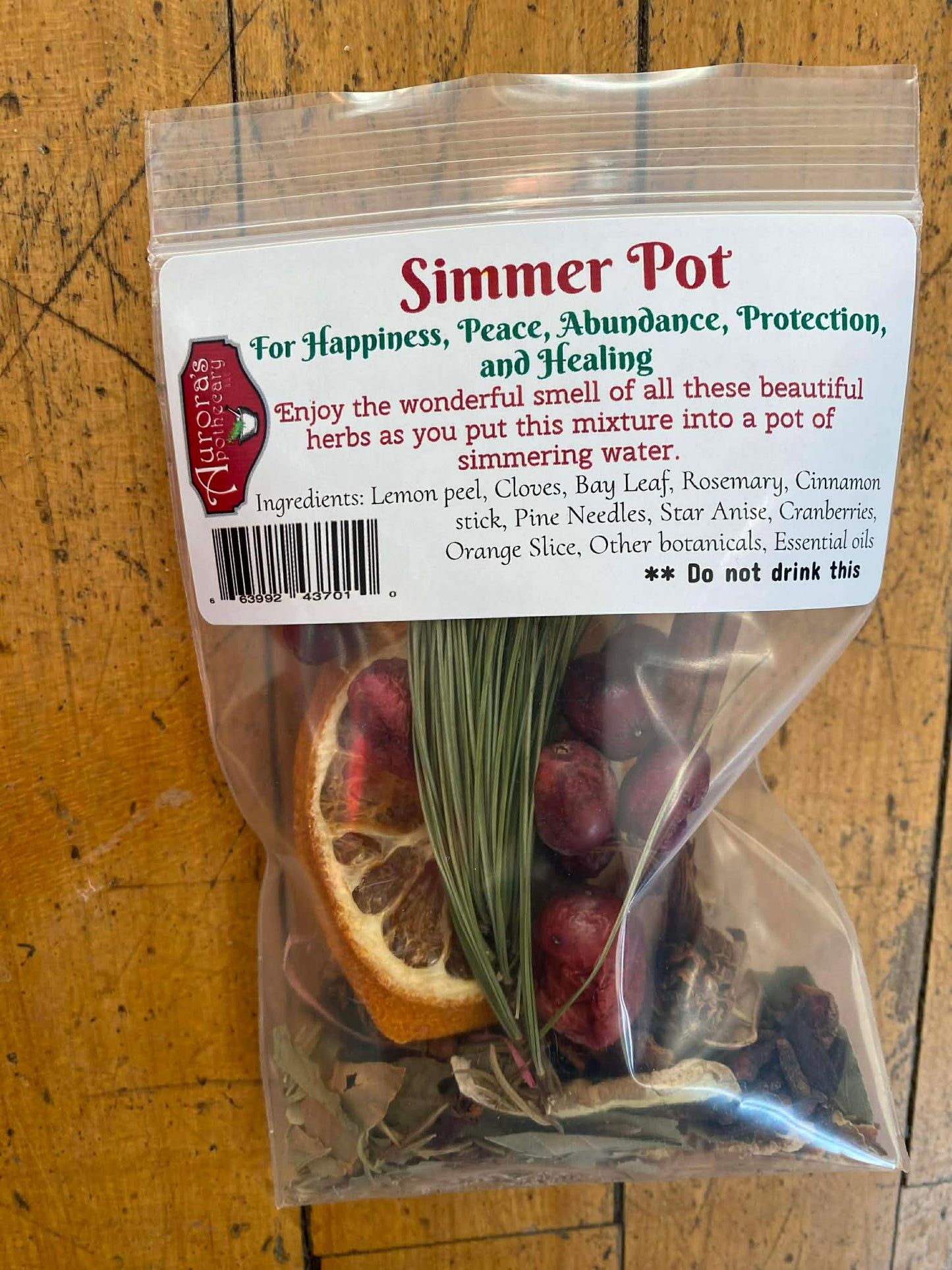 Handcrafted simmer pot botanical blend with dried orange slices, cranberries, rosemary, cinnamon sticks, and herbs packaged by Aurora’s Apothecary